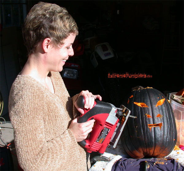 Here is Lisa cutting the flat black pumpkin